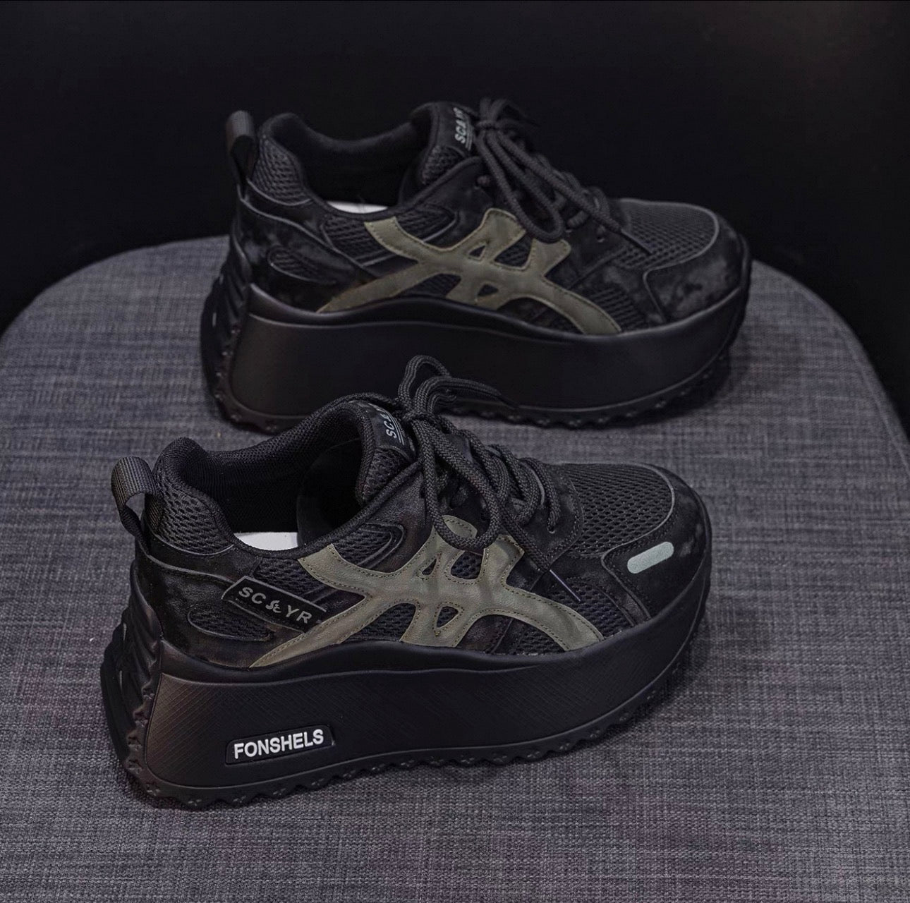 Black platform sneakers with 'FONSHELS' branding on a textured surface.