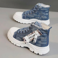 Blue denim high-top sneakers with white soles on a gray surface