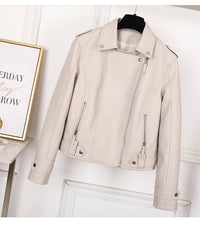 Beige leather jacket on a mannequin against a white wall with a framed picture.