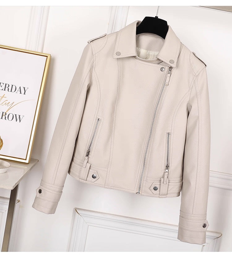 Beige leather jacket on a mannequin against a white wall with a framed picture.