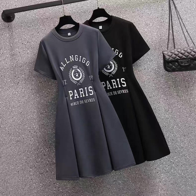 Two t-shirts with text and graphics on hangers against a textured surface.